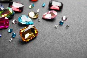 Different beautiful bright gemstones on black background