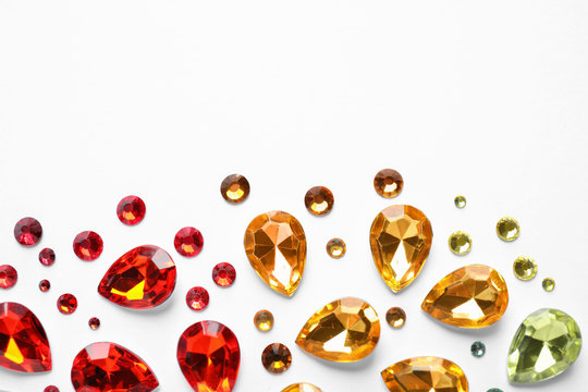 Different beautiful gemstones on white background, top view