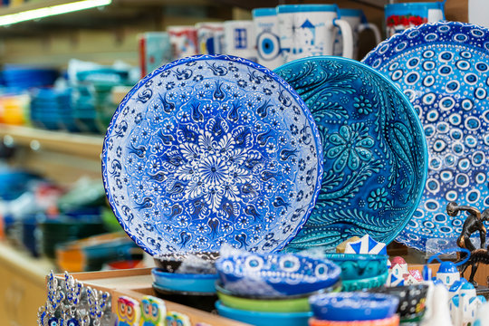 Fototapeta Traditional colorful greek souvenir ceramic plate for sale for tourists in a street shop, closeup. Kos island, Greece.