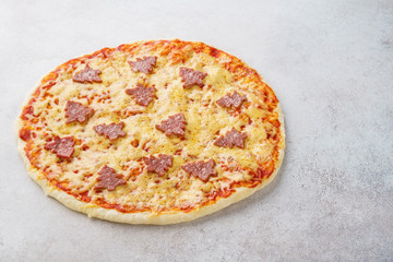 Pepperoni pizza decorated with fir-trees for a Christmas dinner.