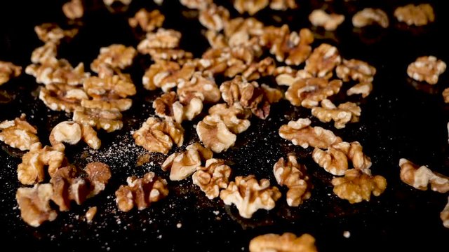 walnuts falling on the black reflective surface. close up shot