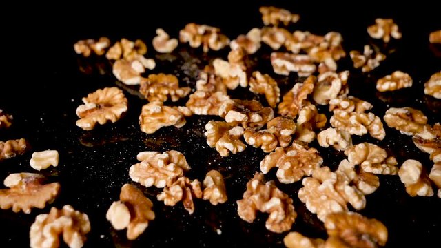 Wallnuts falling on the black reflective surface. Healthy food, source of good proteins and fats, omega 3 and keto diet plan