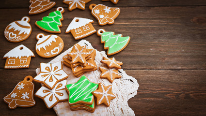festive Christmas gingerbread cookies in the shape of a star lie on a wooden dark brown background.