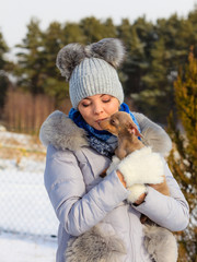 Woman playing with dog during winter