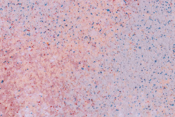 A pattern of milticolored sand with tiny balls of different colors