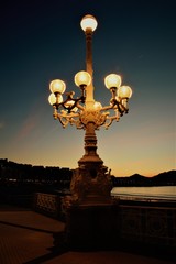 Farola de varios brazos bajo el atarceder en la Concha