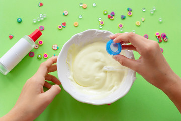 a girl making slime herself. child making slime on green background. 