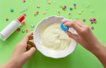 a girl making slime herself. child making slime on green background. 