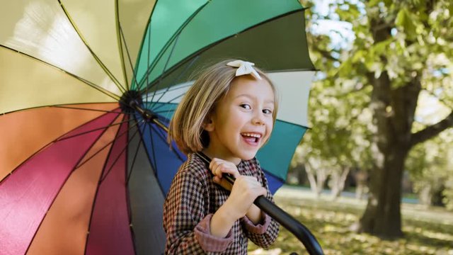 Handheld view of joyful girl looking for shelter with umbrella