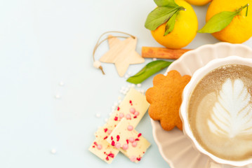 cozy winter coffee break - cappuccino, ginger cookies, chocolate, cinnamon, tangerines