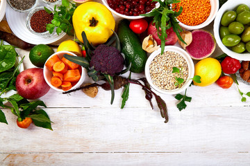 Healthy food selection, clean eating. Fruit, vegetable, seeds, superfood, cereals, leaf vegetable on white background, copy space, top view..