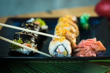 Sushi Set. Various rolls on a wooden plate. On dark rustic background