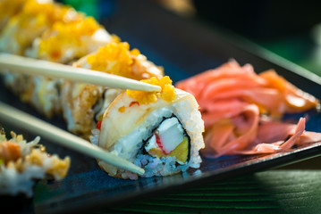 Sushi Set. Various rolls on a wooden plate. On dark rustic background