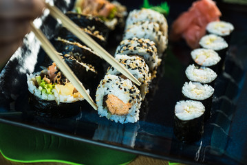 Sushi Set. Various rolls on a wooden plate. On dark rustic background