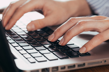 Woman working at home office hand on keyboard close up
