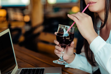 Woman sitting in coffee shop drink juice and using phone