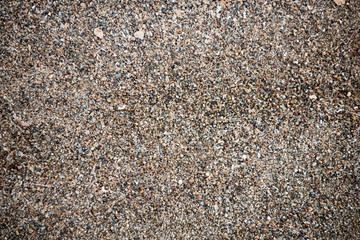 The texture of the beach with coarse sand. The texture of the pebble beach