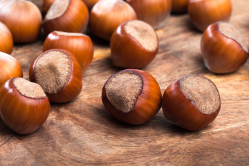 close up of hazelnuts on wooden table .