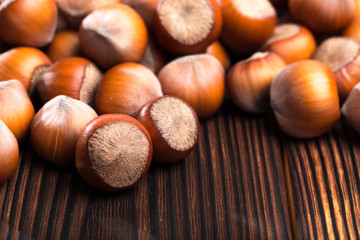 close up of hazelnuts on wooden table .