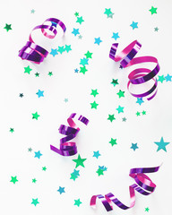 Holiday background with colorful cyan stars confetti and violet curly ribbon. Christmas and New Year decorations.
