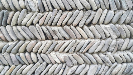 The texture of the Old Stone Wall, made of gray and colorful stones from the beach, an interesting...