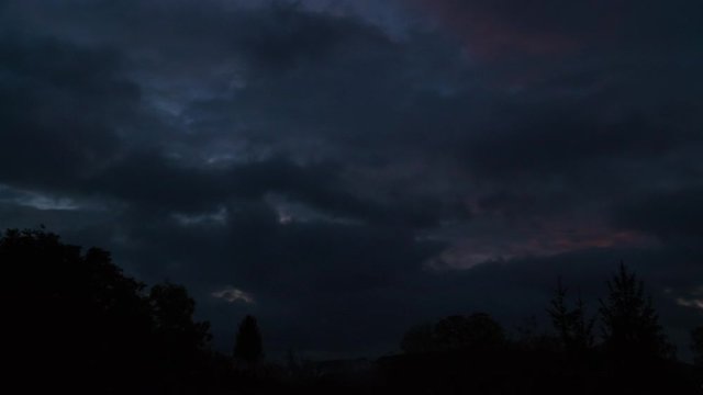 Timelapse. Dawn after thunderstorm. Heavy dark clouds revealing golden sunbeams breaking through. 4K 4096x2304