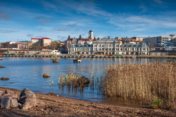 Panorama of the embankment with ancient beautiful buildings of the city of the middle-century city of Vyborg in Russia on an autumn sunny day