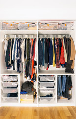 Colored clothes in the closet. Storage of clothes and things in the closet