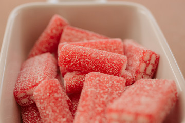 Close up of sugary candies as background. Jelly sweets in a bowl. Red sugary candy ready to eat.