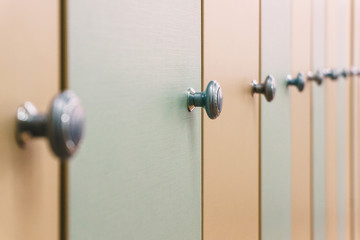 identical doors in a row of school lockers made of wood painted in different colors