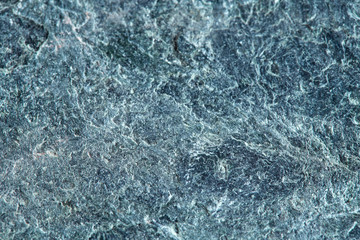 Grainy texture of greenish-gray natural stone. Natural backgrounds and textures. Decor and design. Top view.