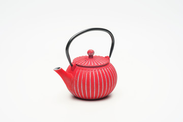 Red cast iron teapot on a white background.