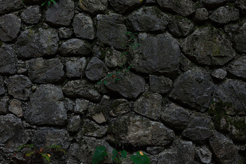 Dark grey stone wall, mixed small and big stones