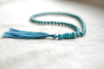 long blue  turquoise prayer beads for praying on light background 