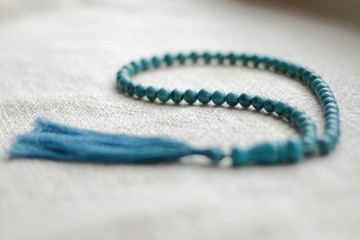 long blue  turquoise prayer beads for praying on light background 