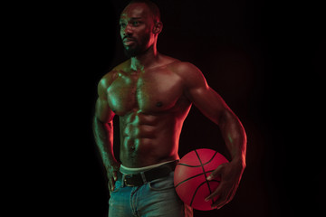 African-american muscular young basketball player in action of gameplay training, practicing in...