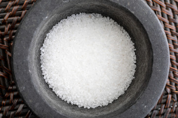 Close-up with fat salt. In stone mortar. Rustic appearance.