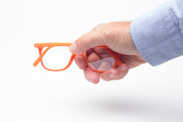 Gafas y lentes de colores y montura de plástico, de diseño, sobre fondo blanco y en la mano de...