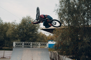 Professional young sportsman cyclist with bmx bike at skatepark