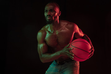African-american muscular young basketball player in action of gameplay training, practicing in...