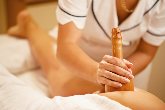 Close-up of therapist massaging female customer during maderotherapy treatment.