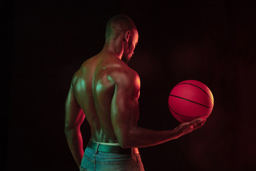 African-american muscular young basketball player in action of gameplay training, practicing in...