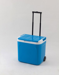 Blue cooling box with adjustable handle and wheels isolated
