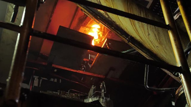 Burning blanks of glass bottles in an industrial stove in Glassworks