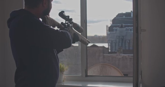 A man in black gloves opens a window. CSI Hired assassin getting ready for a shot, killer.