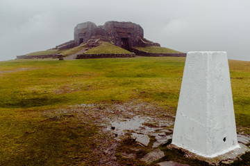 Triangulation point on deserted Moel Famau peak North wales Clwydian Range on wet misty day