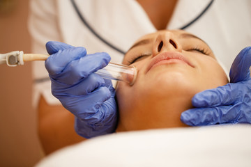 Close-up of woman having vacuum face cleaning at beauty spa.