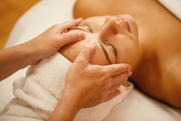 Close-up of beautiful woman having head massage at beauty spa.
