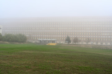 Fototapeta na wymiar Photo of the autumn city in the fog. Cloudy weather, boring mood. Buildings and roads in the fog.