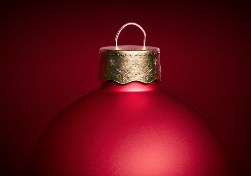 Close up of matte red christmas ball against dark red background